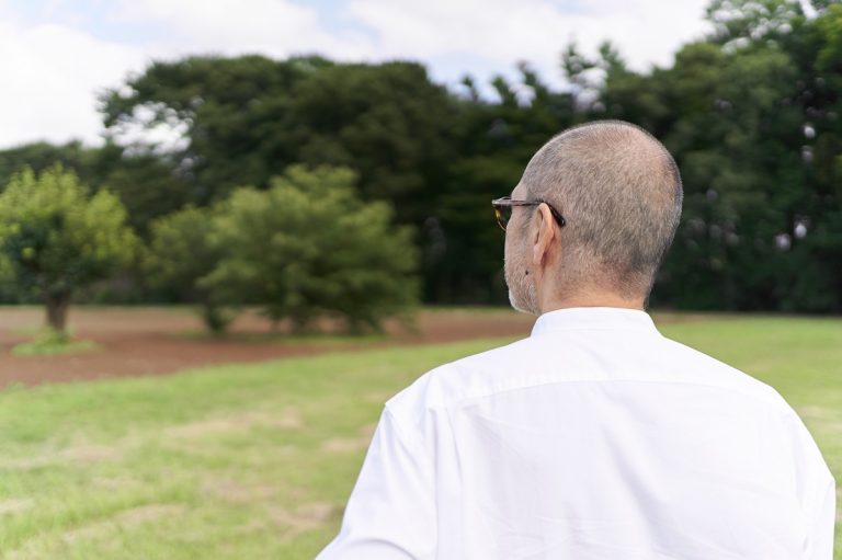 A man looking at a vacant lot.
